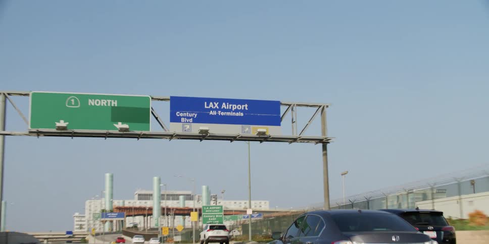 Cars travel on a california highway towards the los angeles airport exit