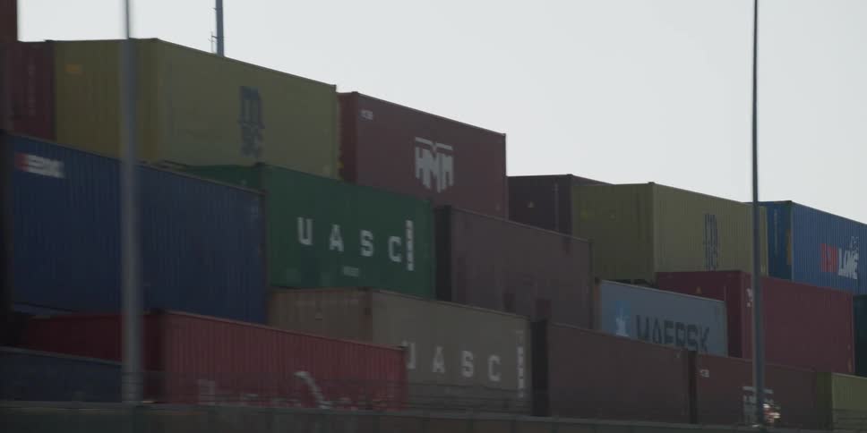 Driving by stacks of shipping containers on the freeway