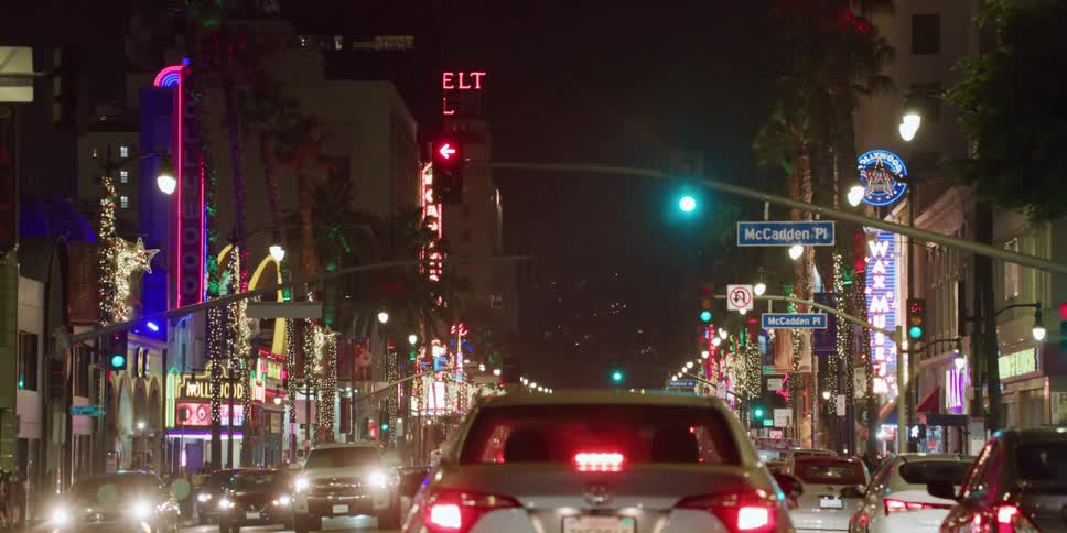 Cars are driving through a downtown city at night