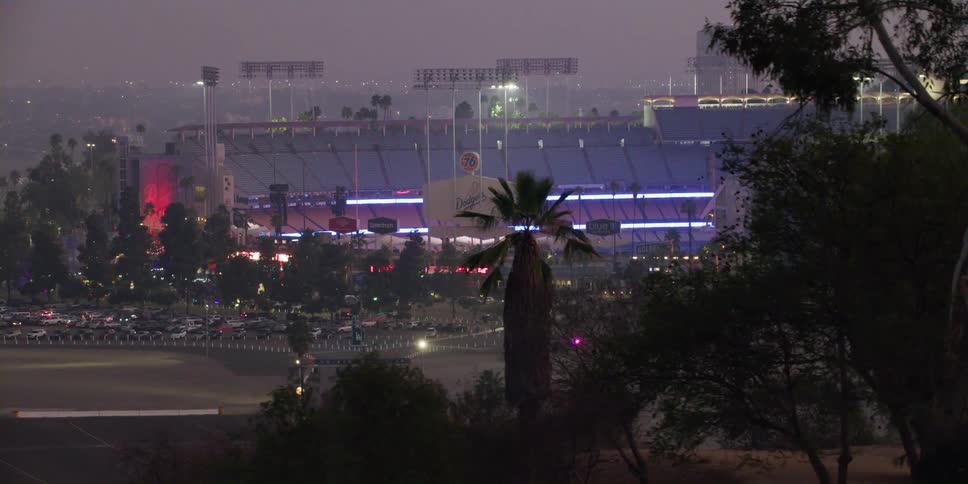 Cars are parked at a stadium in a downtown city