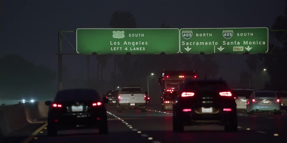 Bumper to bumper traffic passes down a highway at night