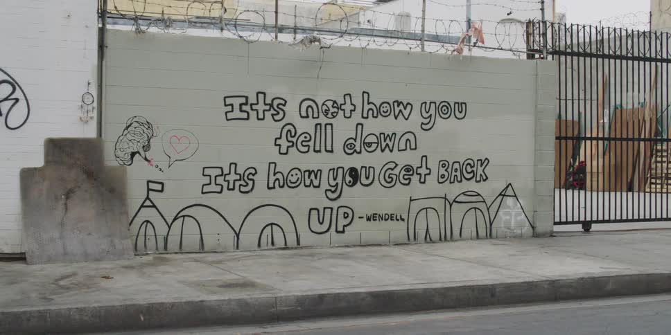 White block wall tagged with a quote in black paint