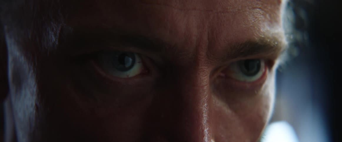 A man kneels down and angrily scowls