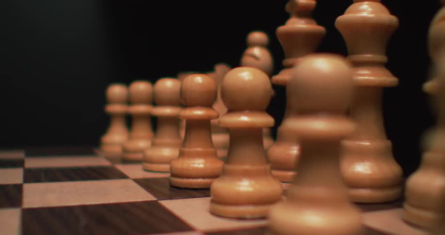 The light reflects on the chess pieces