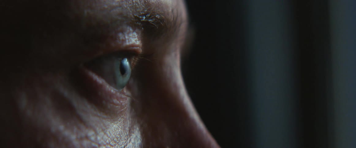 Middle aged and blue eyed man stares into space in gym