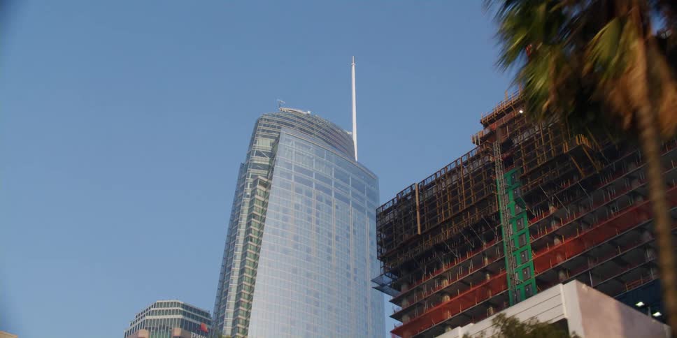High rise office buildings in a city next to a building under construction