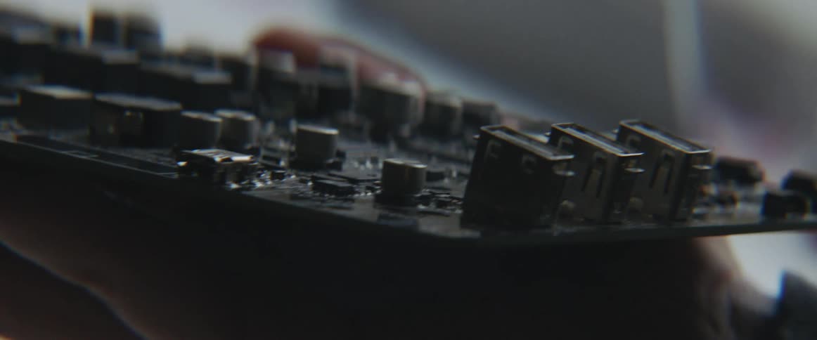 A person is holding a mother board indoors