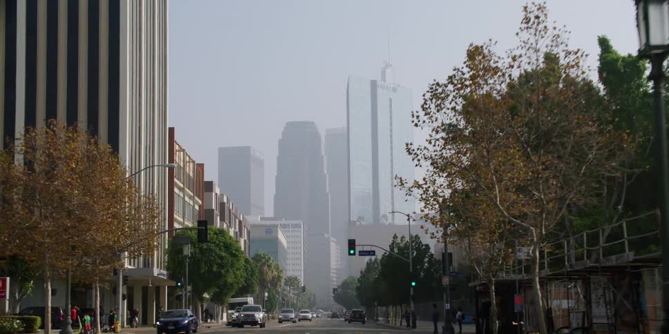 Distant view of high rise buildings seen from vehicle driving down street in the city