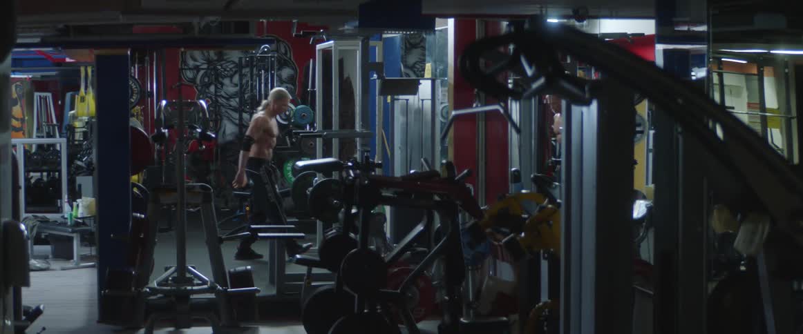 A man is lifting weights in a gym