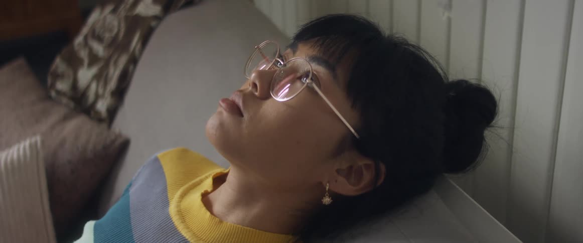A woman is resting on the couch in the daytime