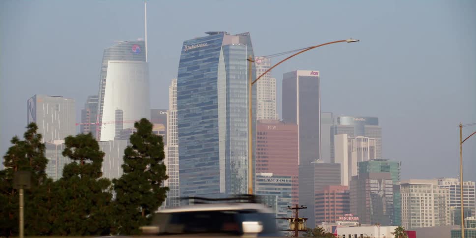Vehicles drive down a highway that passes by downtown