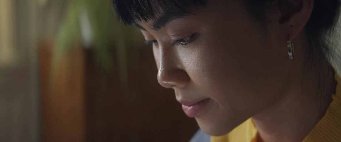 Asian woman smiles slightly while deep in thought