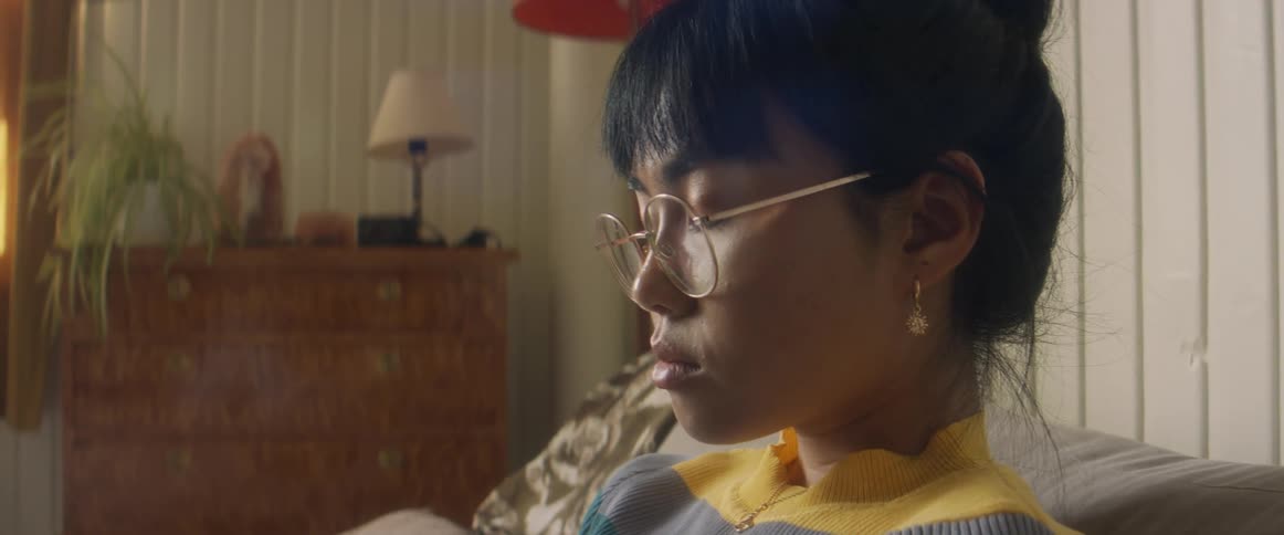 Thoughtful young asian woman wearing round glasses and an earring