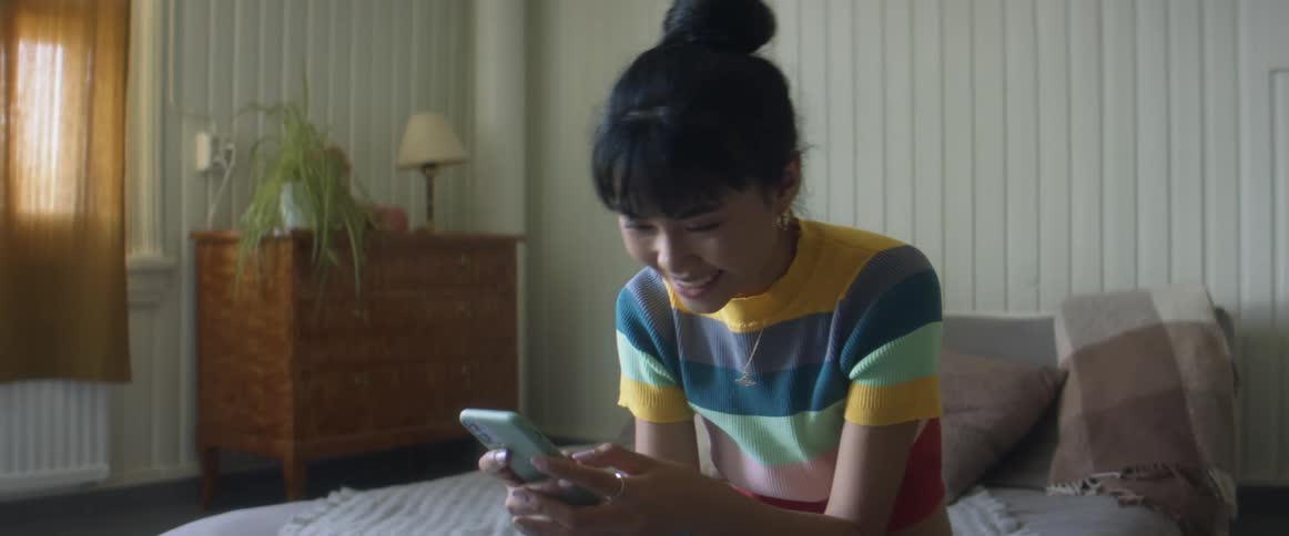 Young asian woman scrolling through social media on cell phone