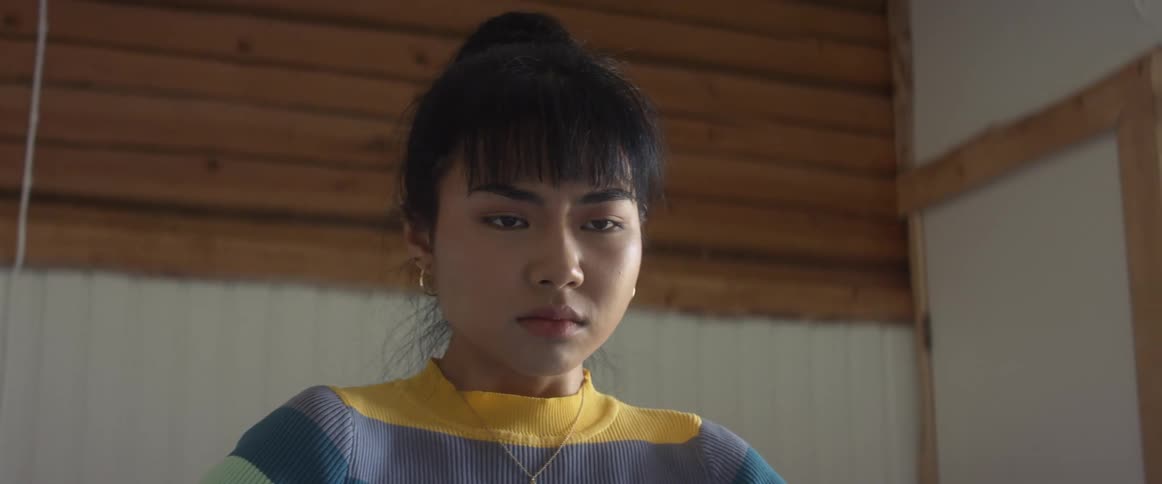 A woman is standing in a room and looks upset