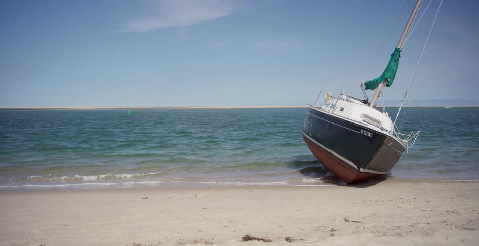 A boat sits on a sandy beach