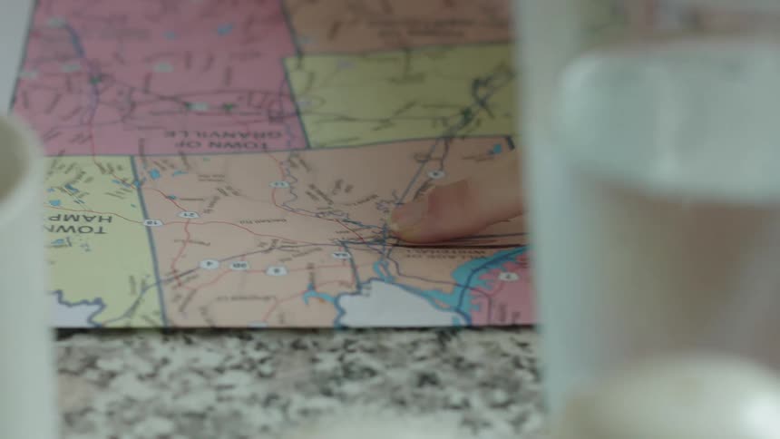 A woman traces her finger along a map