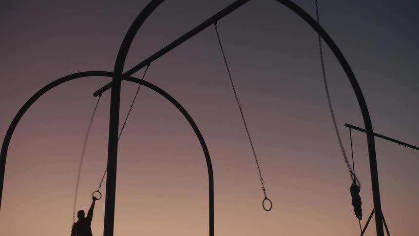 Two people are hanging from the rings