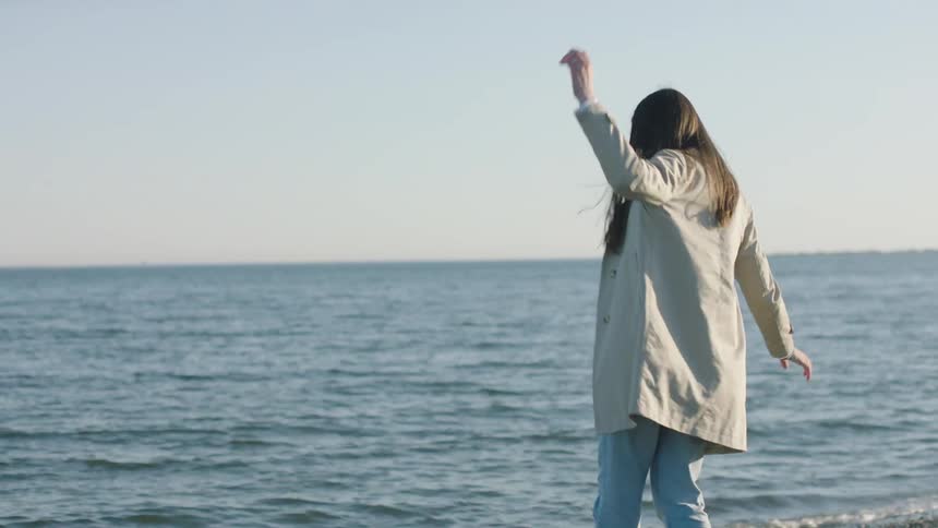 A woman is balancing on the beach
