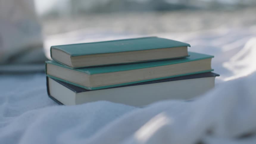Three books sit on the blanket