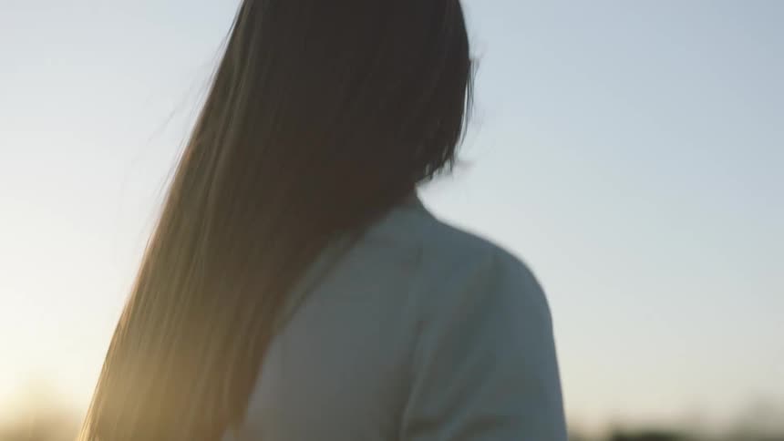 A woman walks outside on a sunny day