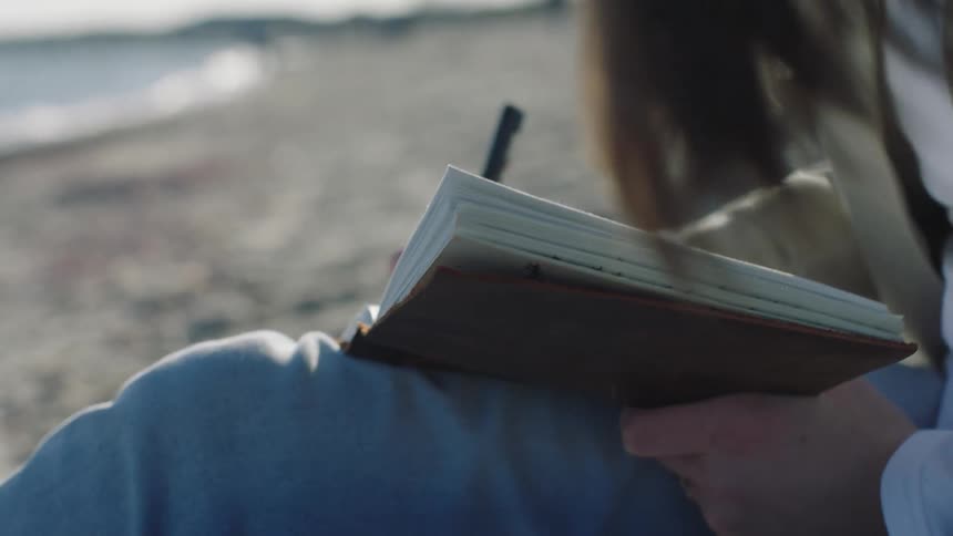 A woman is writing in her notebook