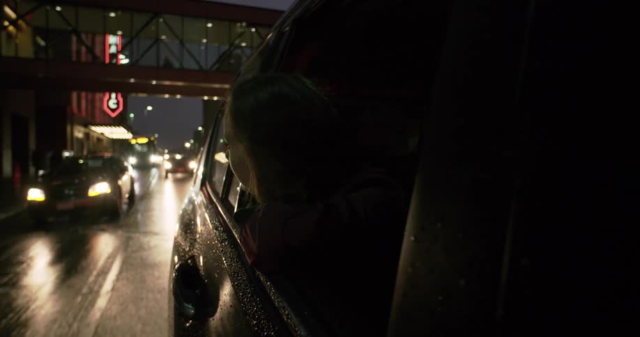 A woman looks out of a car window