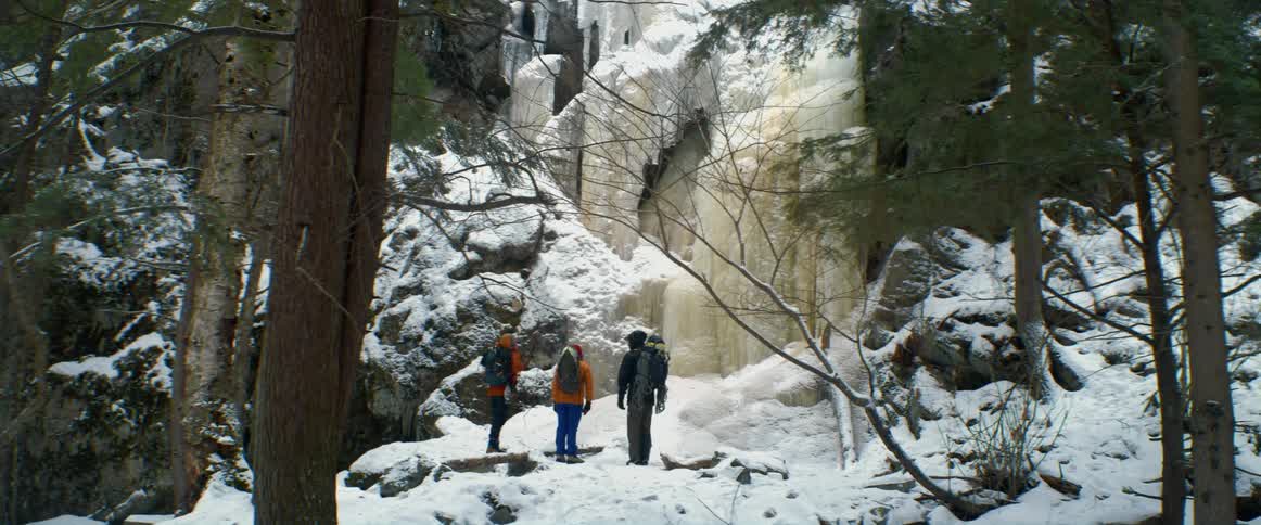 Three people stand by the mountain
