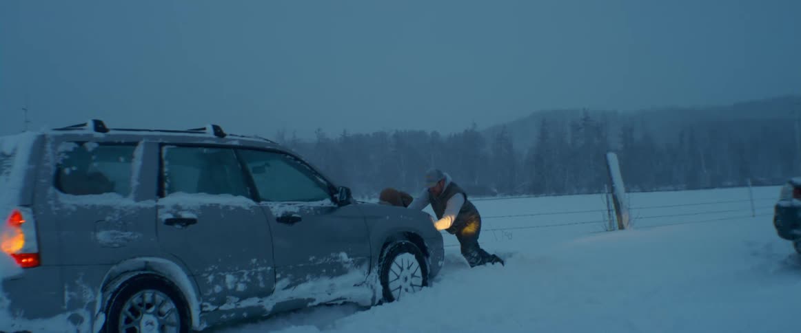 Three men push the car stuck in the snow