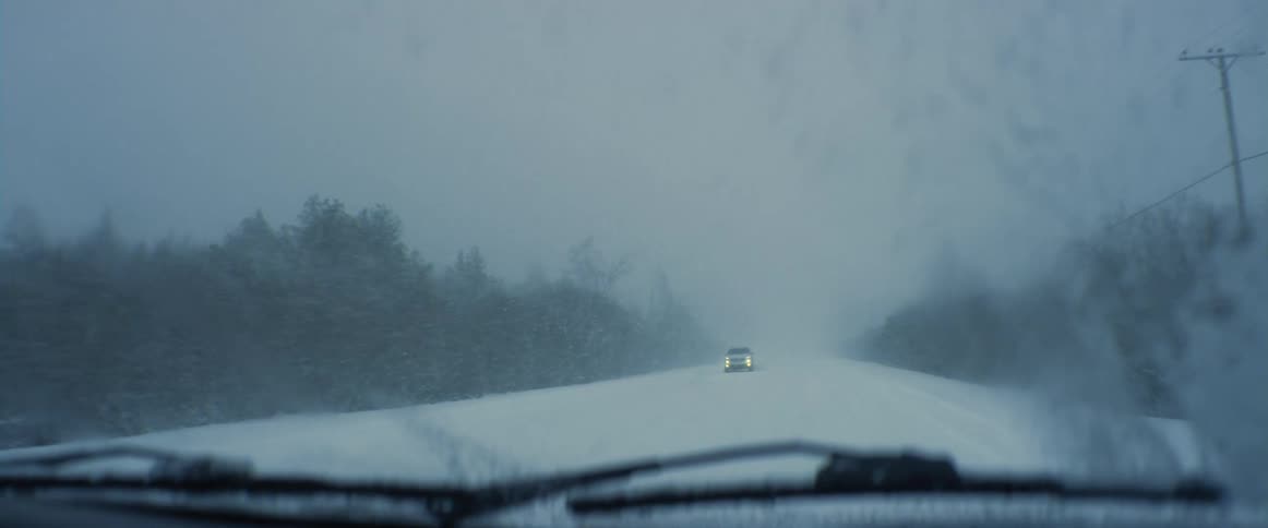 Traveling on a snow covered forest road during a blizzard and another vehicle passes by