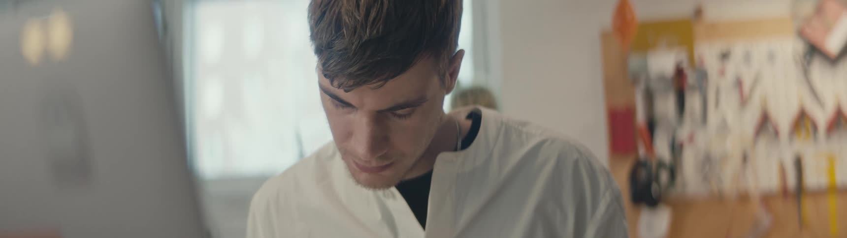A man is focused as he looks downwards and works on something