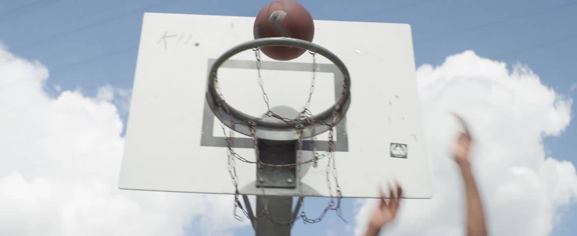 Shirtless man with black shorts plays basketball on court