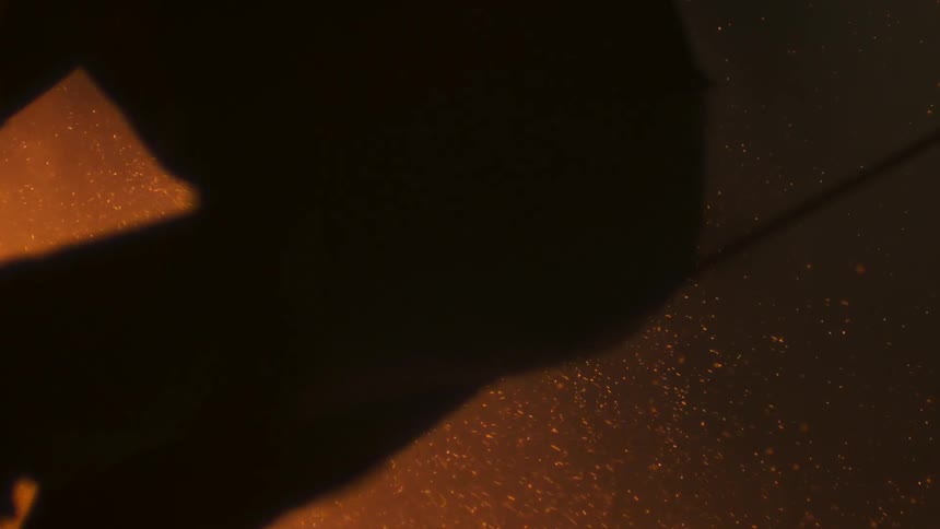 Sparks flying behind a man at night