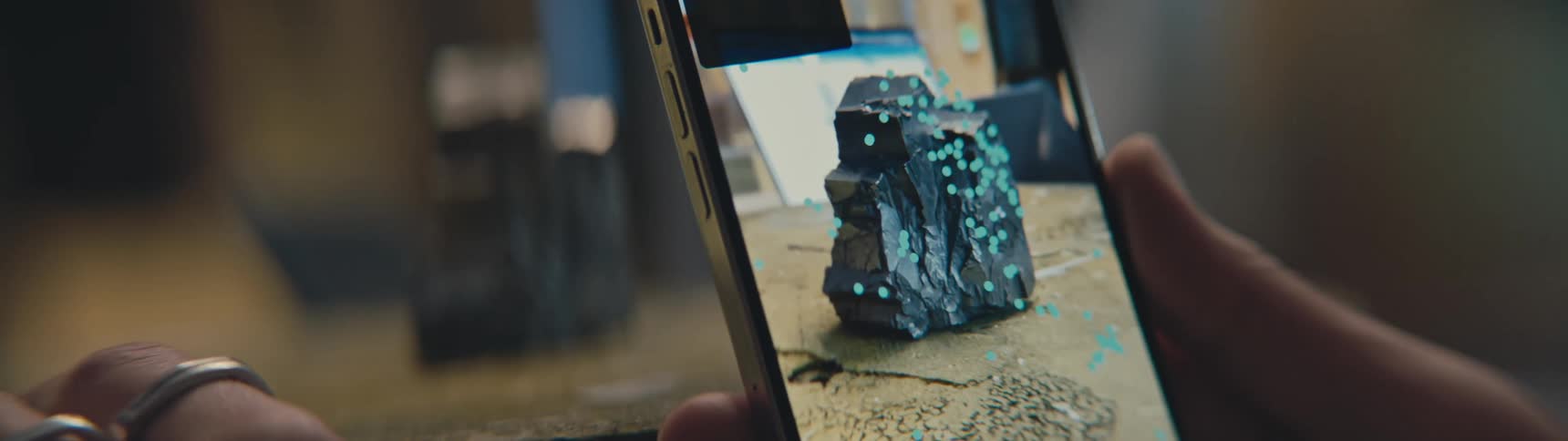 Person holds smartphone app to take photographs and measurements of a large jagged stone