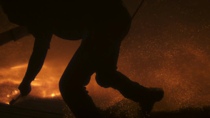 A man drags a flare across the ground