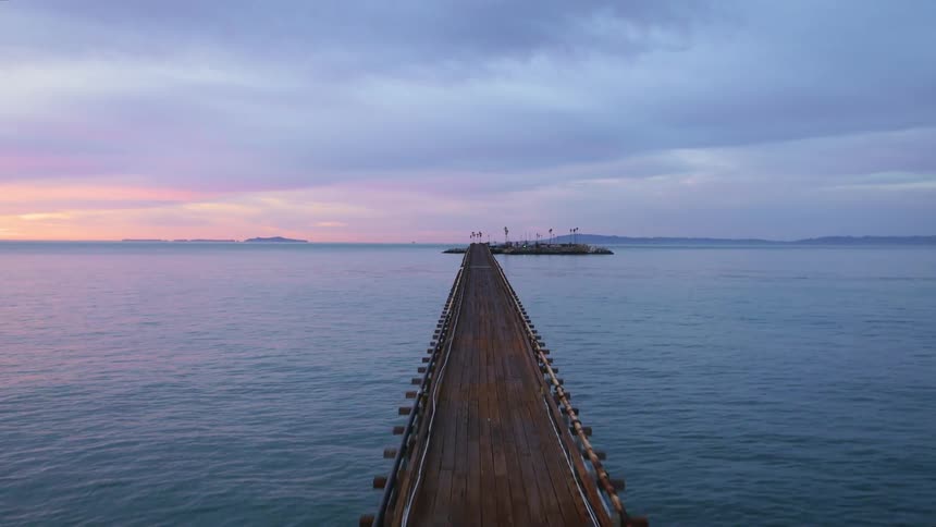A long pier stretches out from the shoreline