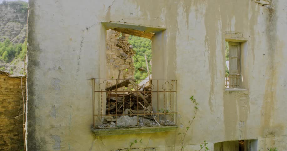 The house is in ruins near the mountain