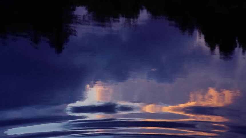 A man looks behind his shoulder as he climbs into a lake