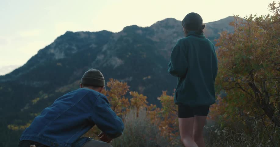 A woman kisses a man on the cheek by the campfire