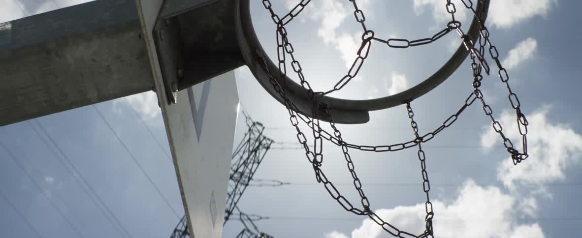The chain from the basketball hoop sways in the wind