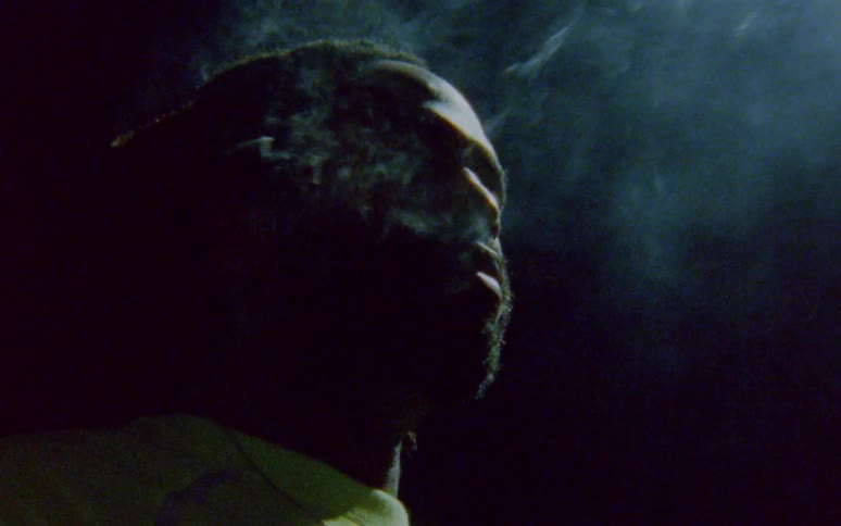 Smoke flows out of mans mouth at night