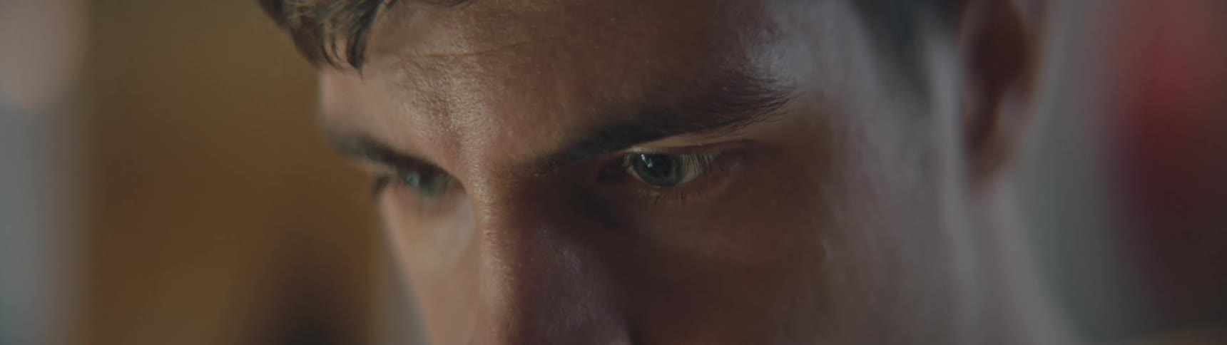 Close up of mans face looking down at laptop in laboratory