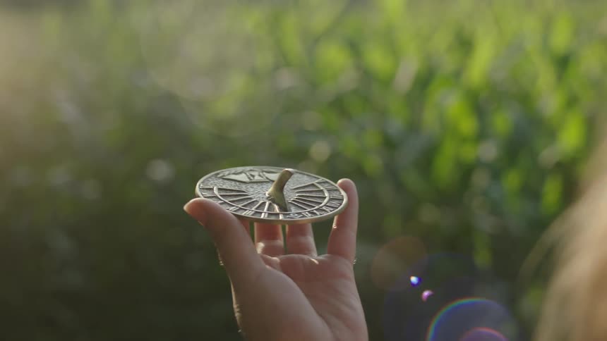 A girl is holding a sundial in her hand
