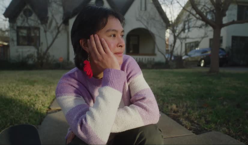 A girl sits on the steps by her house