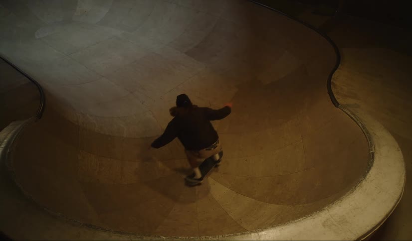 A teenage boy skateboards up a jump and flips at a skateboard park