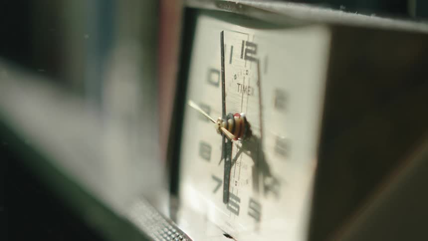 A clock is sitting on a book shelf
