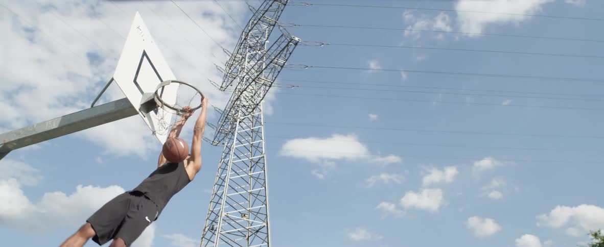 A young man runs and dunks the basketball