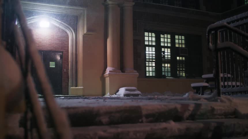A view of snow falling at night outdoors