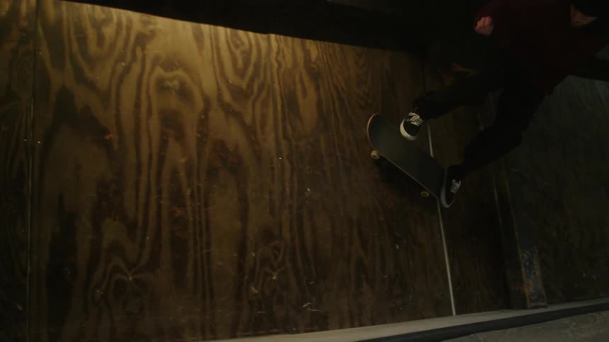 A man is skateboarding on the indoor ramp