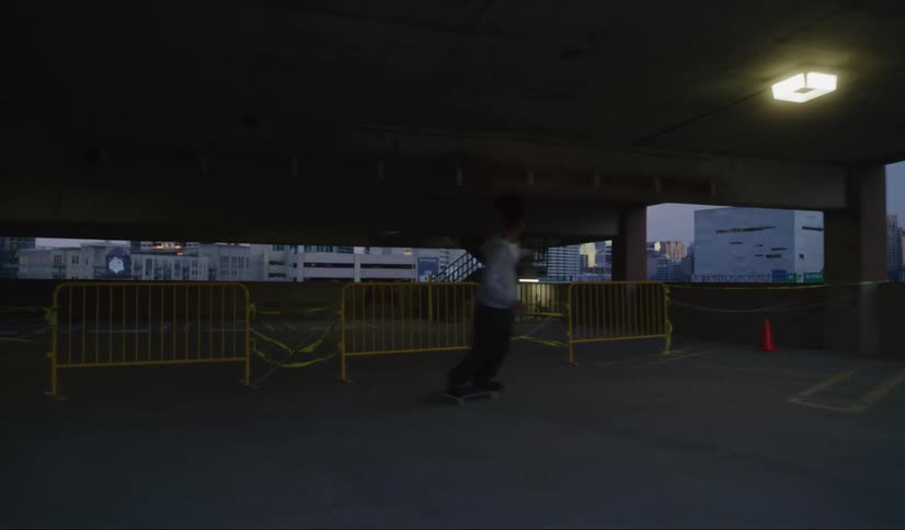 Male and female teenagers ride skateboards in an empty parking lot in the city